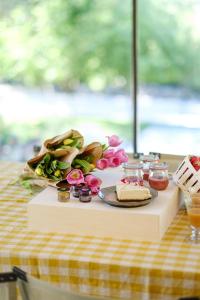 - une table avec une assiette de gâteau et de fleurs dans l'établissement Le Répertoire - Maison Andréa, à Pernes-les-Fontaines