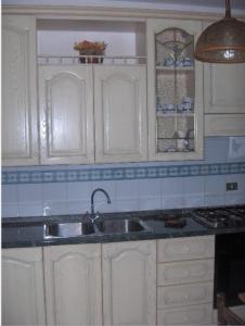 - une cuisine avec des placards blancs et un évier dans l'établissement Ideale per vacanze al mare, à Martinsicuro