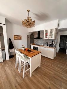 a kitchen with a wooden table and white cabinets at Soñar en la Plaza Cervantes 1 in Alcalá de Henares