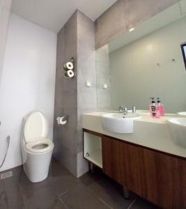 een badkamer met een toilet, een wastafel en een spiegel bij Cozy Home at Near Centre and Airport @ Galacity in Kuching