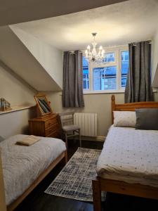 a bedroom with two beds and a chandelier at Anchorlea in Staithes