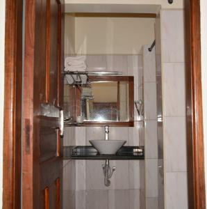een badkamer met een wastafel en een spiegel bij 3 Degrees Hotel in Arusha