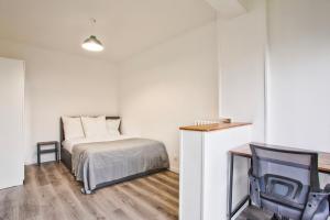 1 dormitorio pequeño con 1 cama y 1 silla en La Casa Will - Family flat for 8, en Hérouville-Saint-Clair