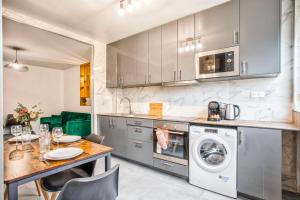 cocina con mesa y lavadora en La Casa Will - Family flat for 8, en Hérouville-Saint-Clair