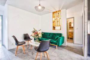 sala de estar con sofá verde y sillas en La Casa Will - Family flat for 8, en Hérouville-Saint-Clair