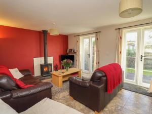 a living room with leather furniture and a fireplace at Penally in Llandysul