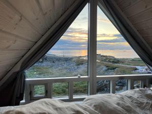 Whale View Vacation House, Ilulissat في إيلوليسات: غرفة نوم مطلة على المحيط من النافذة