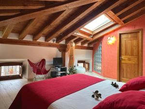 a bedroom with a large bed with a red bedspread at Casa rural Sierra de Prádena in Prádena