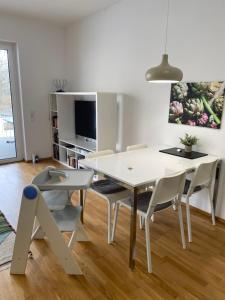 a white dining room with a white table and chairs at Ebelsberger Terrassen in Linz