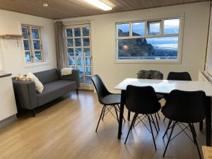 sala de estar con mesa, sillas y sofá en Whale View Vacation House, Ilulissat en Ilulissat