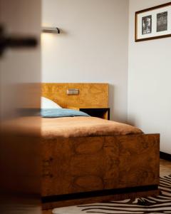 1 dormitorio con 1 cama con cabecero de madera en Hotel Monopol, en Katowice