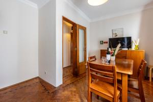 Muralha Holiday Apartments في لاغوس: غرفة طعام مع طاولة وكراسي خشبية