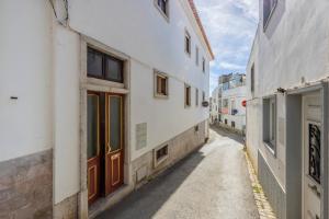 un callejón entre dos edificios blancos con una puerta en Muralha Holiday Apartments, en Lagos