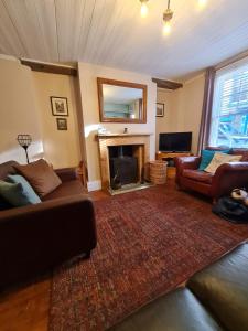 a living room with two couches and a fireplace at Anchorlea in Staithes