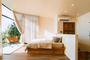 a bedroom with a bed and a large window at AKANO Doichang in Ban Huai Khai
