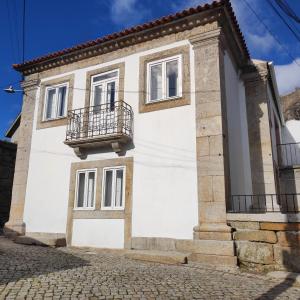 Casa bianca con balcone su una strada di Casa da Capela a Celorico da Beira