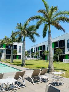 a group of chairs and palm trees in front of a building at 931 Ballito Groves in Ballito