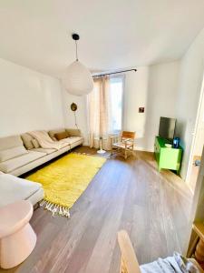 - un salon avec un canapé blanc et un tapis jaune dans l'établissement La Villa Billard - 200 m2 - Jardin, à Saint-Nazaire