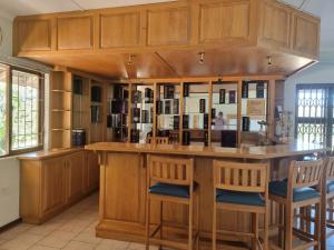 a kitchen with a large wooden island with bar stools at LeadingFarm in Margate