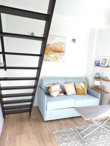sala de estar con sofá azul y escaleras en Chambre avec mezzanine dans une maison d'artiste en Rueil-Malmaison