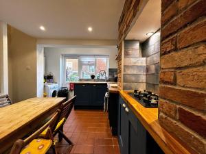 a kitchen with a counter and a brick wall at Hastings Old Town Tackleway privileged Sea Views whole house 3 beds in Hastings