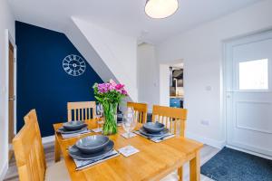 a dining room with a wooden table with a vase of flowers at 4 bed property, Bolton , Manchester in Egerton