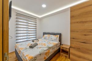 a small bedroom with a bed and a window at Lux Apartman Kleopatra Vip Bogic in Zlatibor