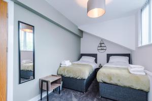 - une chambre avec 2 lits et un miroir dans l'établissement 4 bed property, Bolton , Manchester, à Egerton