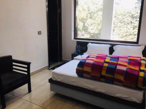 ein Schlafzimmer mit einem Bett mit einer bunten Decke darauf in der Unterkunft RV Lodge in Bulandshahr