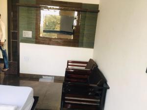 Zimmer mit einem Spiegel, einer Kommode und einem Bett in der Unterkunft RV Lodge in Bulandshahr
