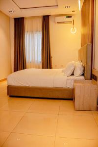 ein Schlafzimmer mit einem großen Bett vor einem Fenster in der Unterkunft Polo Grand Hotel in Maiduguri