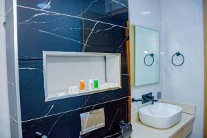 ein Bad mit einem Waschbecken und einem Spiegel in der Unterkunft Polo Grand Hotel in Maiduguri