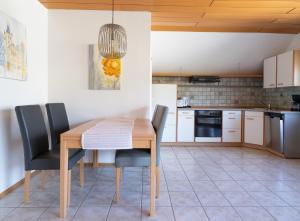 eine Küche mit einem Esstisch aus Holz und Stühlen in der Unterkunft Haus Elfriede in Konz
