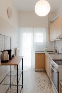 a kitchen with white cabinets and a table and a sink at G & K Cozy Apartments in Athens