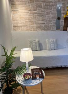 een woonkamer met een bank en een tafel met een lamp bij Studio Olea in Koper