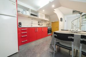 una cocina con armarios rojos y una mesa con sillas. en Barcelona Apartment Near Park Güell, en Barcelona