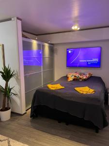 une chambre avec un lit avec une télévision au mur dans l'établissement Matkatoimisto lähellä keskustaa, à Porvoo