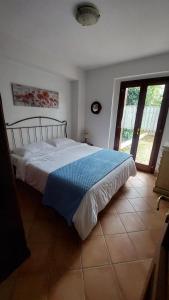 a bedroom with a bed with a blue blanket at Garden House Alfedena in Alfedena