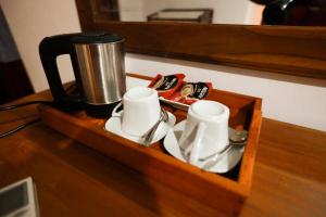 un vassoio di legno con 2 tazze e una macchinetta del caffè di Stellar Inn a Peradeniya