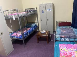 a room with two bunk beds and a table at Dream valley hostel in Abu Dhabi