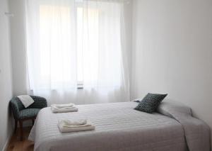 1 dormitorio con 1 cama con 2 toallas en Waterfront balcony I Grani 2 Resort Style Suite en Livorno