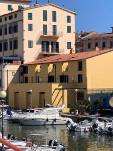 un grupo de barcos atracados en un puerto deportivo junto a un edificio en Waterfront balcony I Grani 2 Resort Style Suite en Livorno
