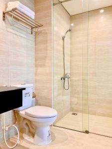a bathroom with a toilet and a glass shower at Plouton Hotel in Phú Quốc