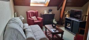 a living room with a couch and a tv at Location chambre dans villa in Villers-Robert