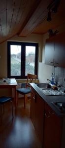 d'une cuisine avec un évier, une table et une fenêtre. dans l'établissement Haus-Irmgard, à Neu Schloen