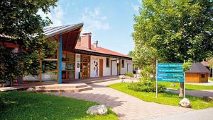 un bâtiment avec un panneau bleu devant lui dans l'établissement Ferienhäuser im Feriendorf Weissensee im Allgäu F1, à Hafenegg