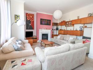 a living room with two white couches and a fireplace at Victorian Town House in Weymouth