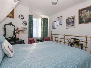 a bedroom with a bed with a blue comforter at Victorian Town House in Weymouth