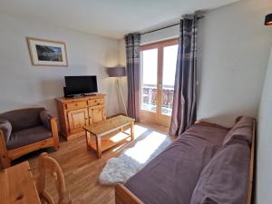 una camera con letto, divano e TV di Pracondu OUTDOOR & FUN appartement 1 chambre avec balcon by Alpvision Résidences a Nendaz
