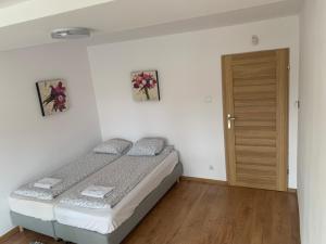 a small bedroom with a bed and a wooden door at B&B vis a vis Zamku in Malbork